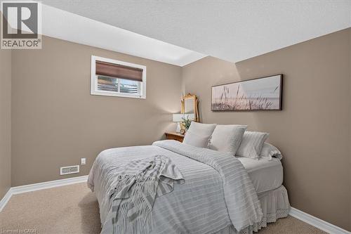 Carpeted flooring, neutral wall tones, window with roller shade, and white trim accents - 515 Woodward Drive, Mount Brydges, ON 
