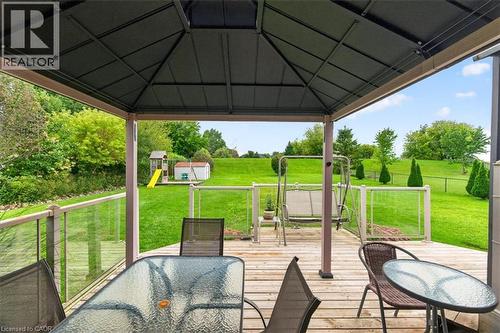 Expansive outdoor deck with a permanent gazebo structure, wood-finish flooring, and clear panel railings - 515 Woodward Drive, Mount Brydges, ON 