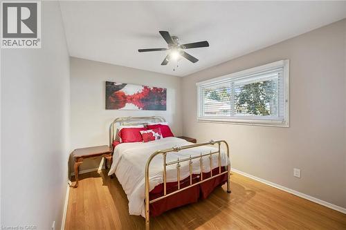 Wood-finish flooring, single window with blinds, ceiling fan with integrated lighting, and neutral wall tones - 35 Crosby Drive, Kitchener, ON 