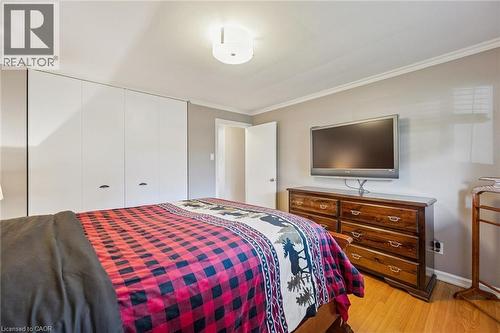 Wood-finish flooring with a ceiling-mounted light fixture, crown molding, and built-in closet doors - 35 Crosby Drive, Kitchener, ON 