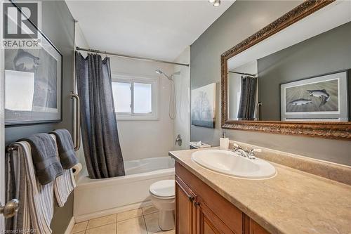 Bathroom featuring a vanity with an integrated sink, wood-finish cabinetry, and a large decorative mirror - 35 Crosby Drive, Kitchener, ON 