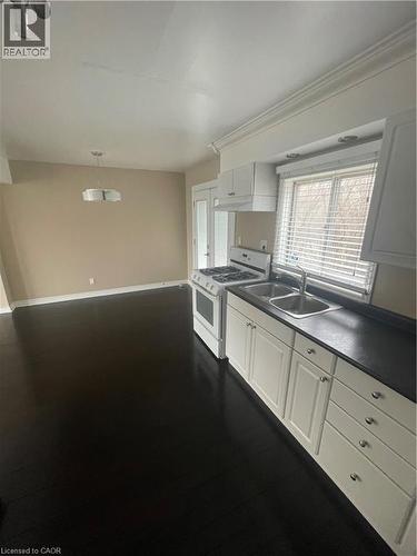 Kitchen with gas range, hanging light fixtures, white cabinetry - 124 Avalon Place, Kitchener, ON 