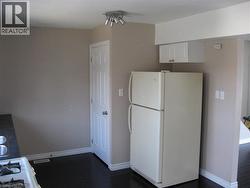 Kitchen featuring white cabinetry and white appliances - 