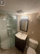 Bathroom featuring vanity, shower stall, and light tile patterned floors - 
