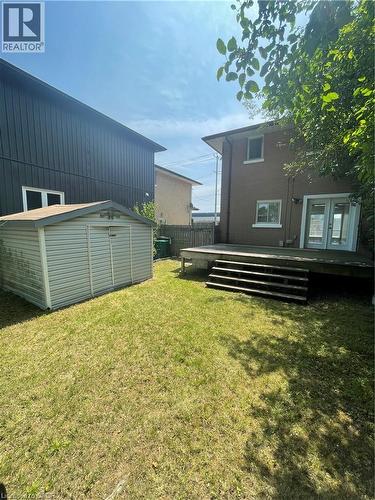 Spacious backyard with a wood deck, multiple steps, and a storage shed - 124 Avalon Place, Kitchener, ON 