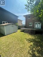 Spacious backyard with a wood deck, multiple steps, and a storage shed - 