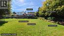 Expansive backyard featuring a wooden deck, ground-level basement with a separate entrance, and established gardens with mature trees - 56 Scenic Wood Crescent, Kitchener, ON 