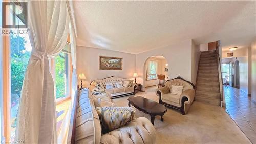 Bay window with sheer drapery, arched doorway, and carpeted flooring - 56 Scenic Wood Crescent, Kitchener, ON 