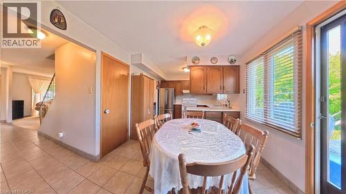 Kitchen with wood cabinetry, stainless steel appliances, and a window with blinds - 56 Scenic Wood Crescent, Kitchener, ON 