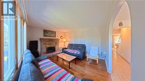 Living area featuring wood-finish flooring, a brick fireplace, and extensive window framing - 56 Scenic Wood Crescent, Kitchener, ON 