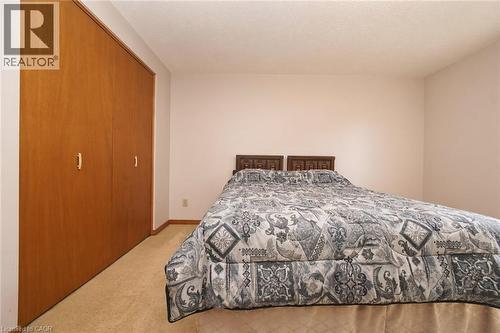 Light-toned wall paint and carpeting, complemented by wood-finish closet doors - 56 Scenic Wood Crescent, Kitchener, ON 