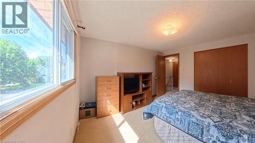 Large windows, ceiling-mounted light fixture, wood-finish bi-fold closet doors, wall-to-wall carpeting, and painted walls - 56 Scenic Wood Crescent, Kitchener, ON 