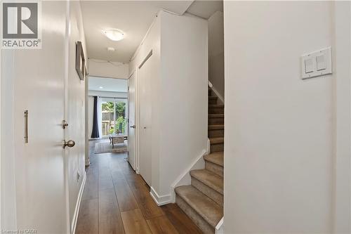 Hallway with wood-finish flooring, flush mount lighting, and a staircase with carpeted treads - 1444 Upper Ottawa Street Unit# 32, Hamilton, ON 
