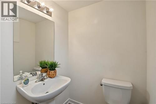 Pedestal sink with chrome faucet, wall-mounted mirror, and vanity lighting - 1444 Upper Ottawa Street Unit# 32, Hamilton, ON 