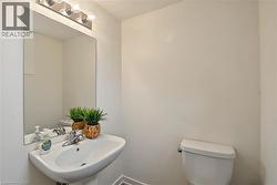 Pedestal sink with chrome faucet, wall-mounted mirror, and vanity lighting - 