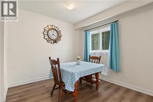 Wood-finish flooring with white baseboards, a window with white trim, and a flush mount ceiling light - 1444 Upper Ottawa Street Unit# 32, Hamilton, ON 
