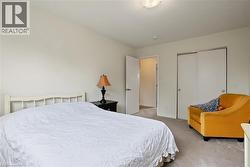 Carpeted flooring, white walls, white interior door, and built-in sliding closet doors - 