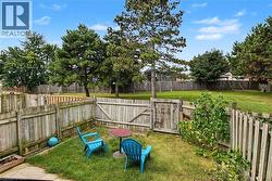 Fenced yard with a grass lawn and mature trees - 