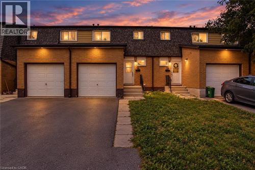 Brick facade, dormer windows, attached garages, paved driveways, and front entry stairs - 1444 Upper Ottawa Street Unit# 32, Hamilton, ON 