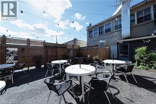 Enclosed patio space featuring wood fencing with decorative panels, string lighting, and a paved surface - 707 E King Street E, Cambridge, ON 