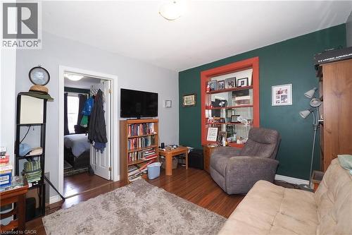 Wood-finish flooring throughout, featuring a distinctive accent wall with a contrasting trim window - 707 E King Street E, Cambridge, ON 