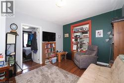 Wood-finish flooring throughout, featuring a distinctive accent wall with a contrasting trim window - 