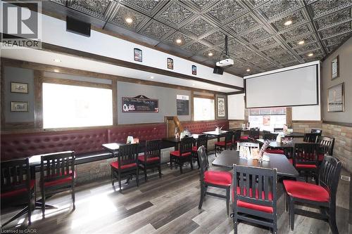 Ornate tin ceiling, recessed lighting, wood-finish flooring, built-in banquette seating, and a mounted projection screen - 707 E King Street E, Cambridge, ON 