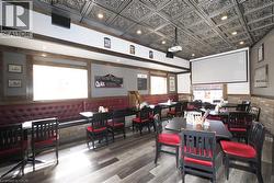 Ornate tin ceiling, recessed lighting, wood-finish flooring, built-in banquette seating, and a mounted projection screen - 