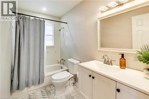 White vanity with integrated sink, rectangular framed mirror, and tiled shower surround with window - 35 Shirlea Boulevard, Keswick, ON 