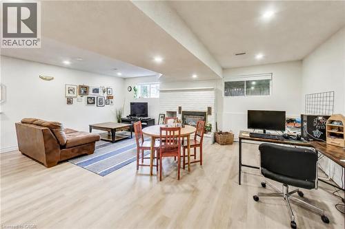 Wood-finish flooring throughout, featuring recessed lighting, a painted brick fireplace, and a built-in window - 35 Shirlea Boulevard, Keswick, ON 