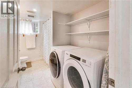 Laundry area featuring a stacked washer and dryer, open shelving, and tile flooring - 35 Shirlea Boulevard, Keswick, ON 
