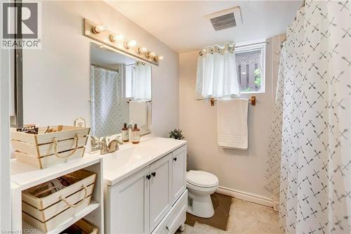 White vanity with an integrated sink, brushed nickel faucet, and a large wall-mounted mirror - 35 Shirlea Boulevard, Keswick, ON 