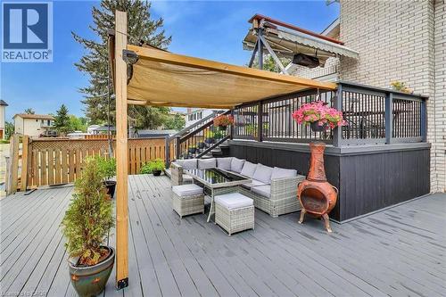 Expansive outdoor deck with gray composite flooring, featuring a pergola with a retractable shade and a built-in privacy wall - 35 Shirlea Boulevard, Keswick, ON 