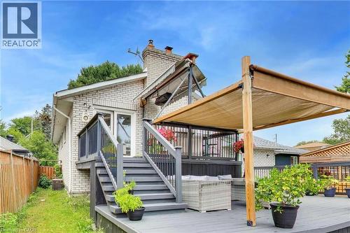 Multi-level decking with a retractable canopy, white brick exterior, and a prominent brick chimney - 35 Shirlea Boulevard, Keswick, ON 
