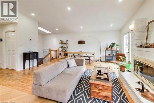 Recessed ceiling lighting, wood-finish flooring, a white brick fireplace with hearth, and a skylight - 35 Shirlea Boulevard, Keswick, ON 