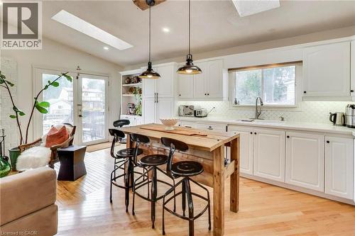 White shaker cabinetry, light wood-finish flooring, white subway tile backsplash, skylight, and double glass-paneled doors - 35 Shirlea Boulevard, Keswick, ON 