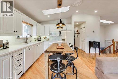 White kitchen cabinetry with black hardware, white countertops, and a white subway tile backsplash - 35 Shirlea Boulevard, Keswick, ON 