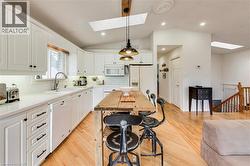 White kitchen cabinetry with black hardware, white countertops, and a white subway tile backsplash - 