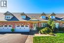 Brick exterior with dormer windows, two garage doors with window inserts, stone walkway, and established landscaping - 31 Book Road Unit# 44, Grimsby, ON 