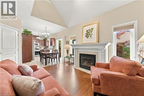 Vaulted ceiling with a gas fireplace featuring a stone surround and a white mantel - 31 Book Road Unit# 44, Grimsby, ON 