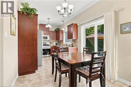 Kitchen with wood-finish cabinetry, stainless steel appliances, and tile flooring - 31 Book Road Unit# 44, Grimsby, ON 