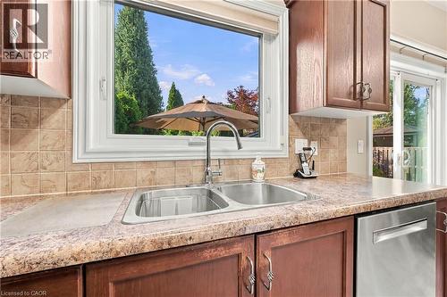 Dual basin stainless steel sink with a high-arc faucet, set within a patterned countertop - 31 Book Road Unit# 44, Grimsby, ON 
