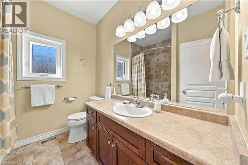 Wood-finish vanity with a single basin sink and light-toned countertop - 31 Book Road Unit# 44, Grimsby, ON 