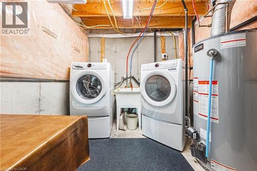 Laundry area featuring a front-load washer, front-load dryer, and utility sink - 31 Book Road Unit# 44, Grimsby, ON 