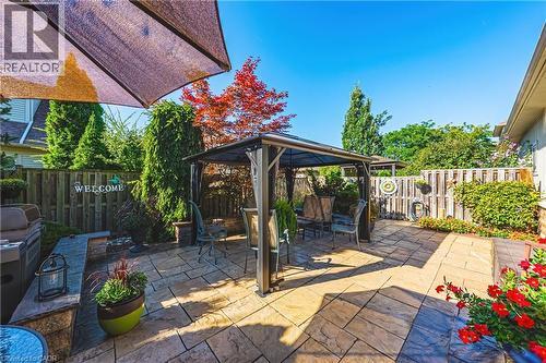 Paver patio with a built-in stone bench and privacy fencing - 31 Book Road Unit# 44, Grimsby, ON 