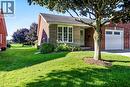 Brick and stone-finish exterior featuring a single garage, front entry, and mature landscaping - 150 Oak Street Unit# 27, Simcoe, ON 