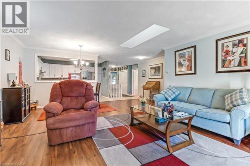Living area featuring wood-finish flooring, a skylight, and crown molding - 150 Oak Street Unit# 27, Simcoe, ON 