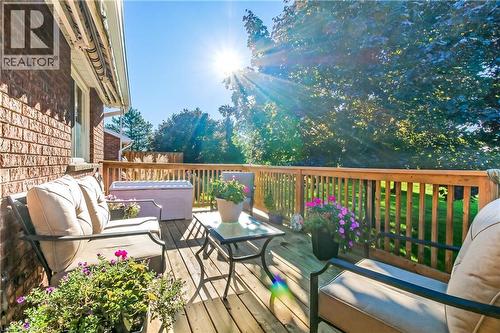 Expansive wood-finish deck with a wood railing system, set against a brick exterior - 150 Oak Street Unit# 27, Simcoe, ON 