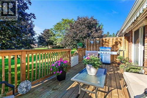 Expansive wood deck with a privacy fence and direct access to a manicured lawn. - 150 Oak Street Unit# 27, Simcoe, ON 