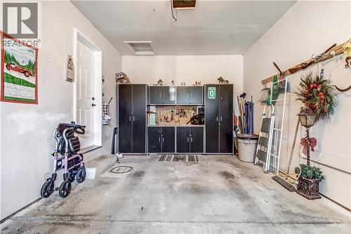 Single car garage with black cabinets for extra storage. - 150 Oak Street Unit# 27, Simcoe, ON 
